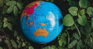 Photo of colourful world globe nestled in greenery with focus on Australia to symbolise topic - Transferring UK Pension - The Tax Implications